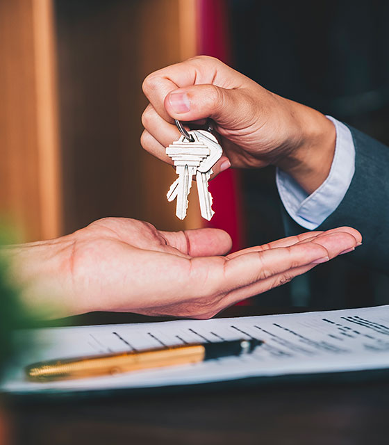 Real Estate - keys being passed from one hand to another